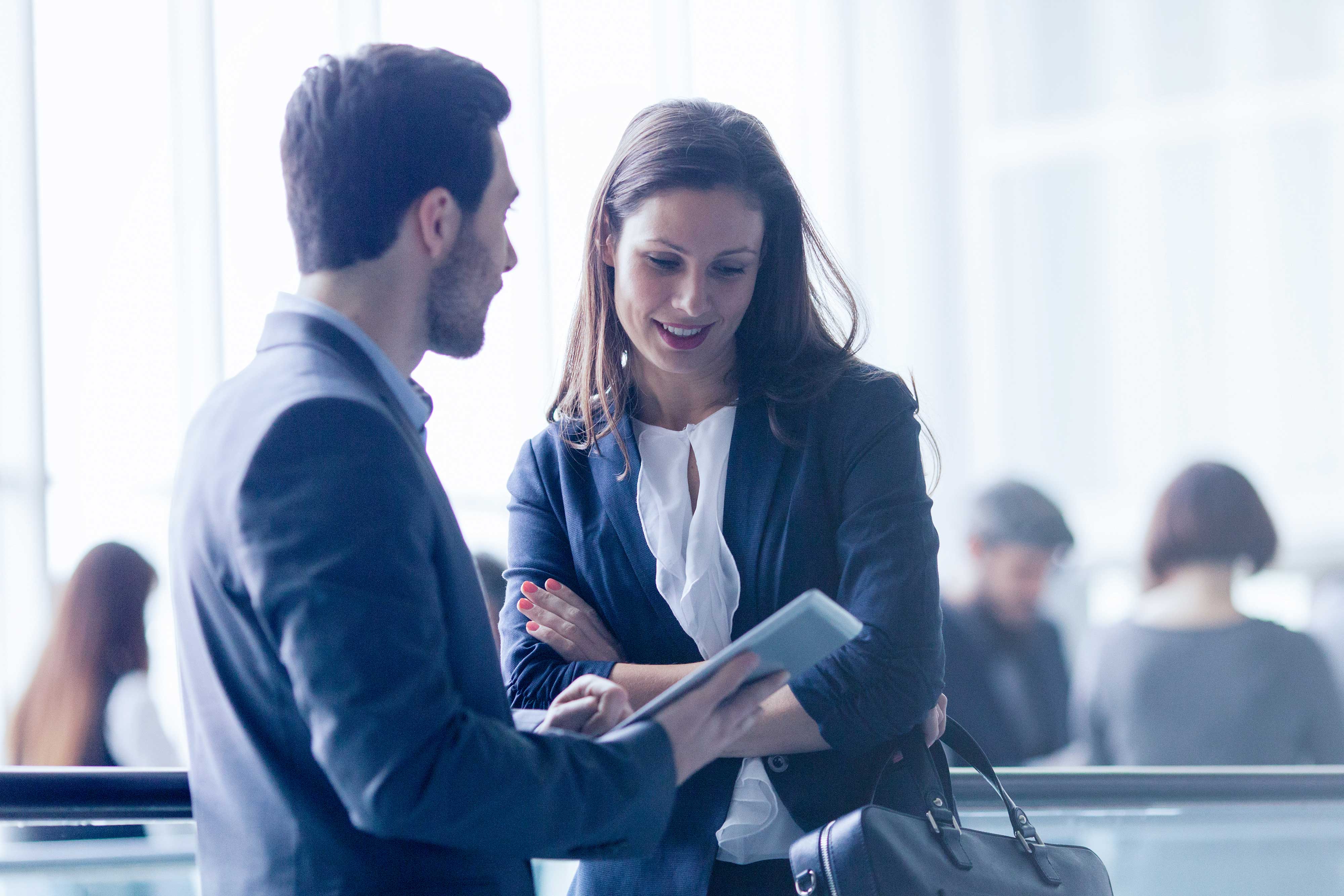 Automatisation de la comptabilité fournisseurs - Couple de jeunes professionnels discutant dans un couloir